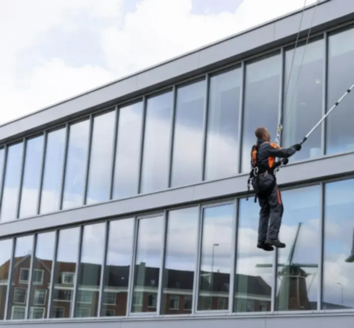 Glazenwasser die ramen van een kantoorpand streeploos reinigt